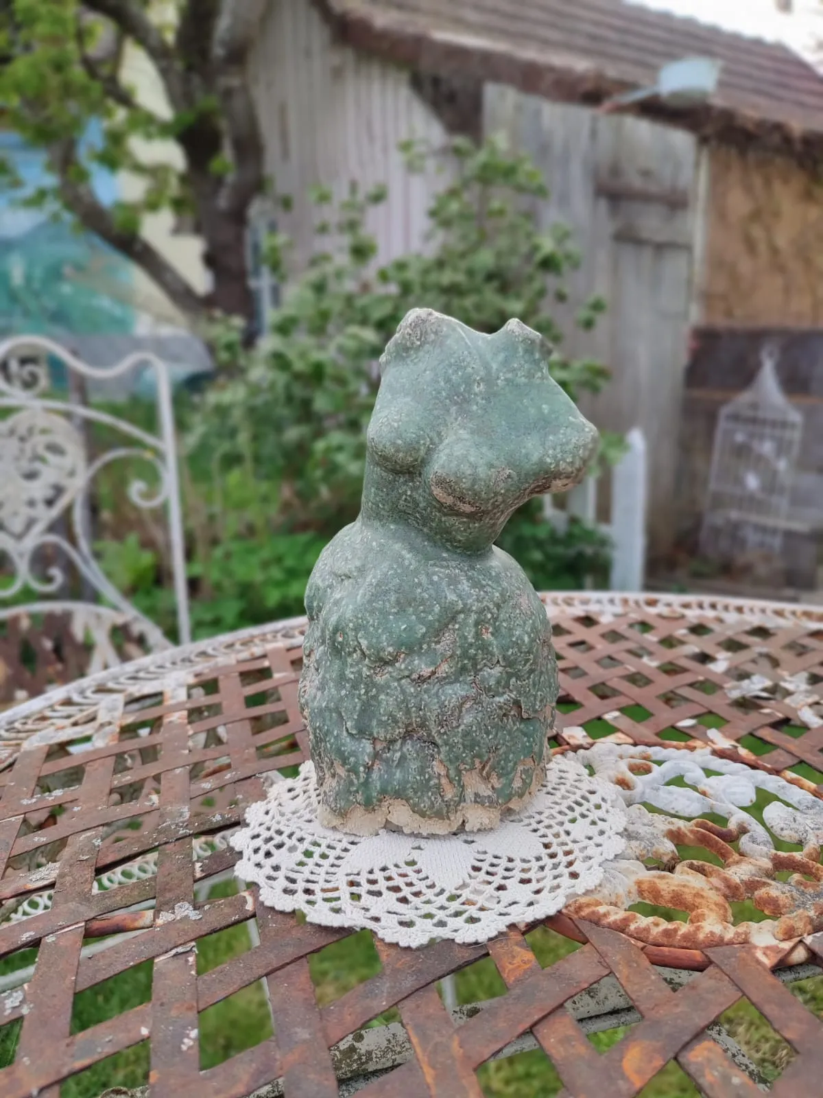 Grün glasierte Keramikfigur im Garten